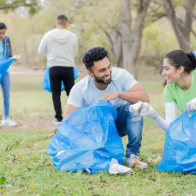 People cleaning up in a field or park.
