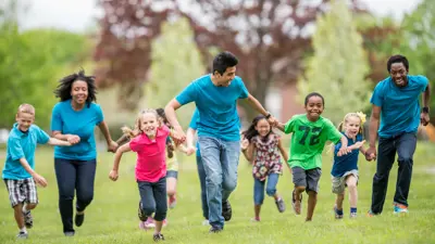 Group of instructors running with kids outside