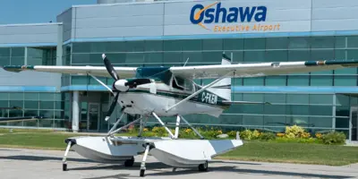 plane with pontoons in front of hanger