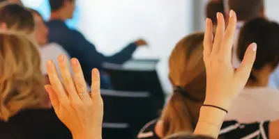 an audience of people some with hands up