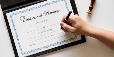 hand signing a Certificate of Marriage