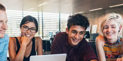 Five students gathered around a computer