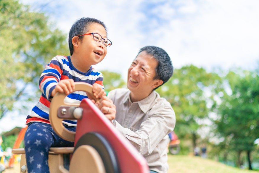 Father with low vision child on slide